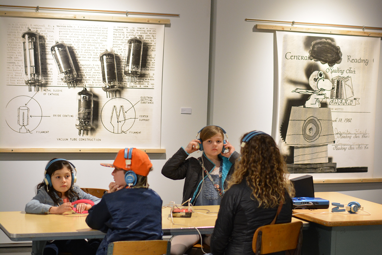 A mother and her three kids listening to the oral history recording at the main listening station.